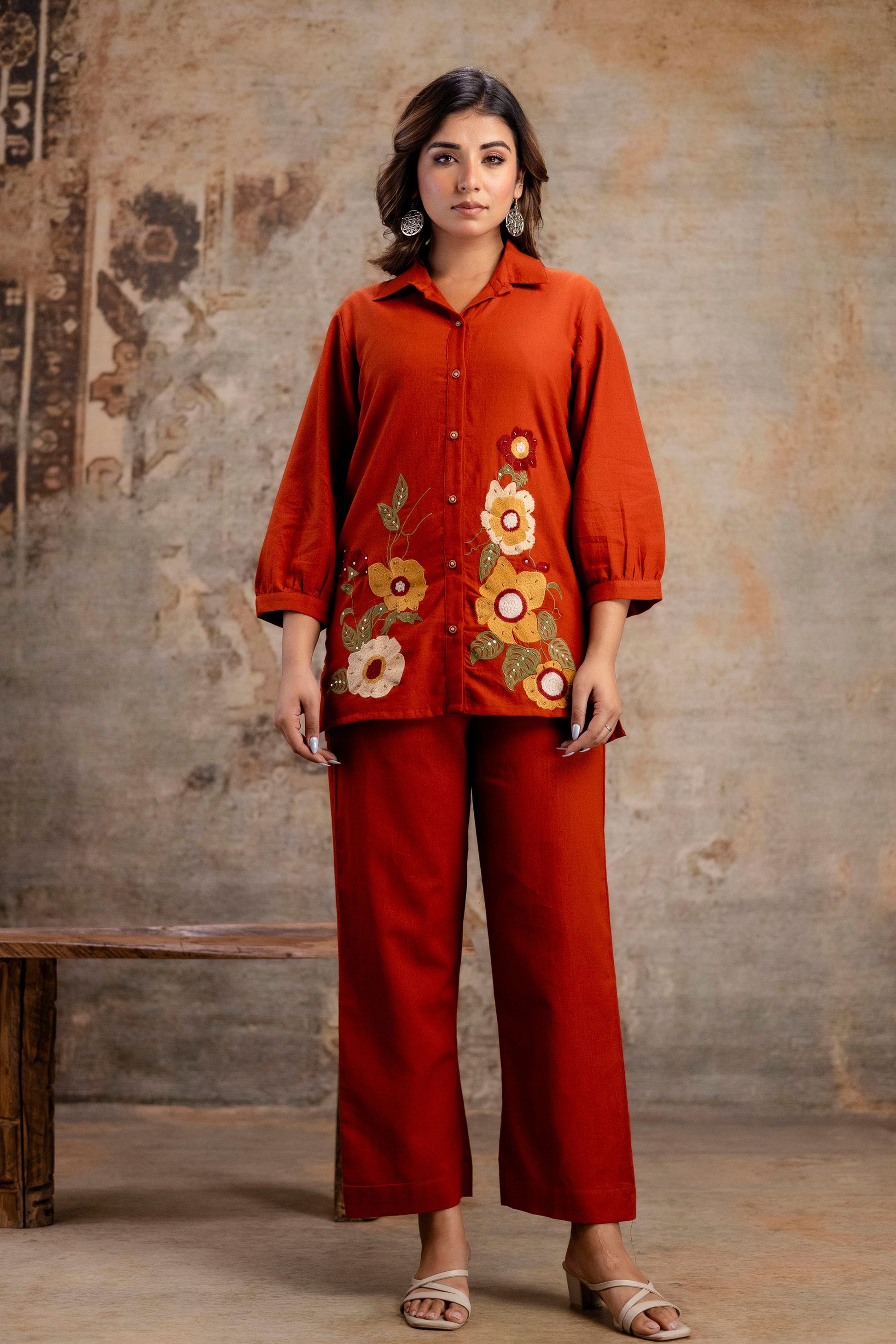 Rust embroidered co-ord set featuring a cropped jacket and high-waisted trousers, showcasing intricate floral patterns.
