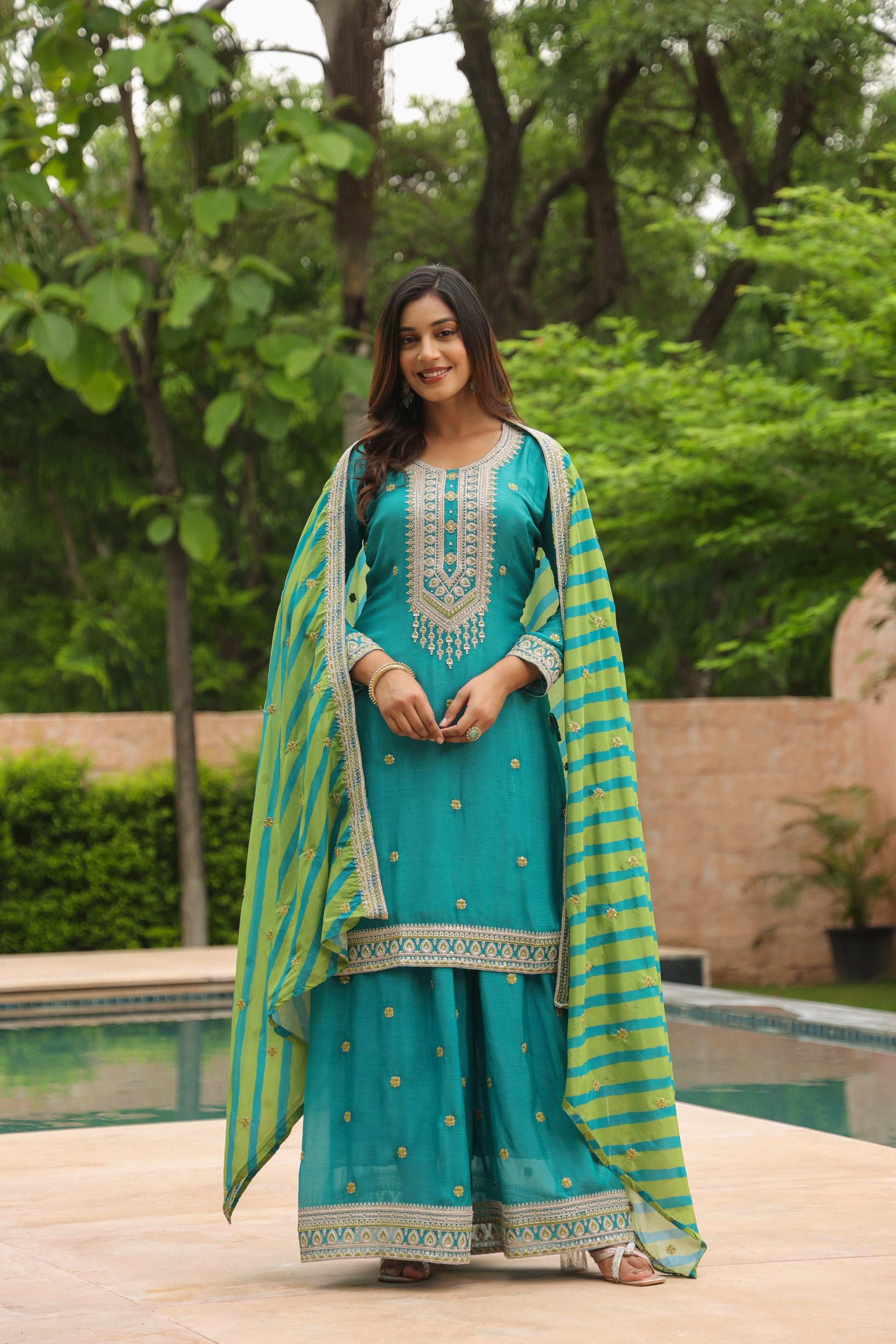 Festive Firozi Palaazo Suit Set with intricate embroidery and striped dupatta.